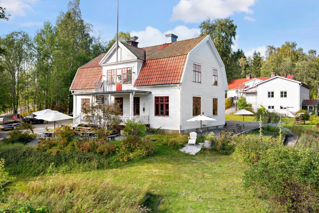 una casa blanca con techo naranja en Sågverket Höga Kusten, en Rö