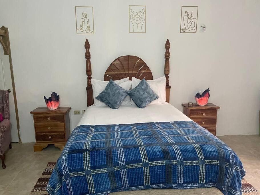 a bedroom with a bed with blue and white sheets and pillows at GraceWay Studio Apt with A/C -3mins walk to beach in Negril