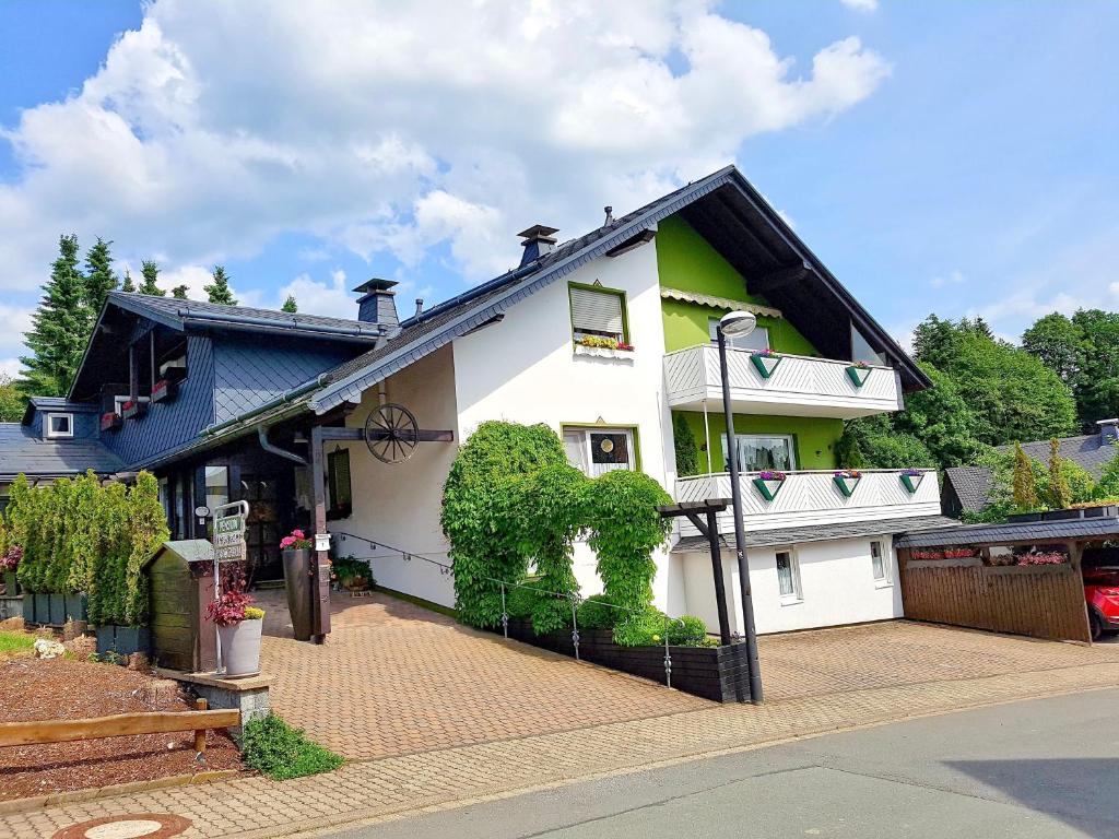 una casa blanca con techo negro en Pension Sonnenheim, en Winterberg