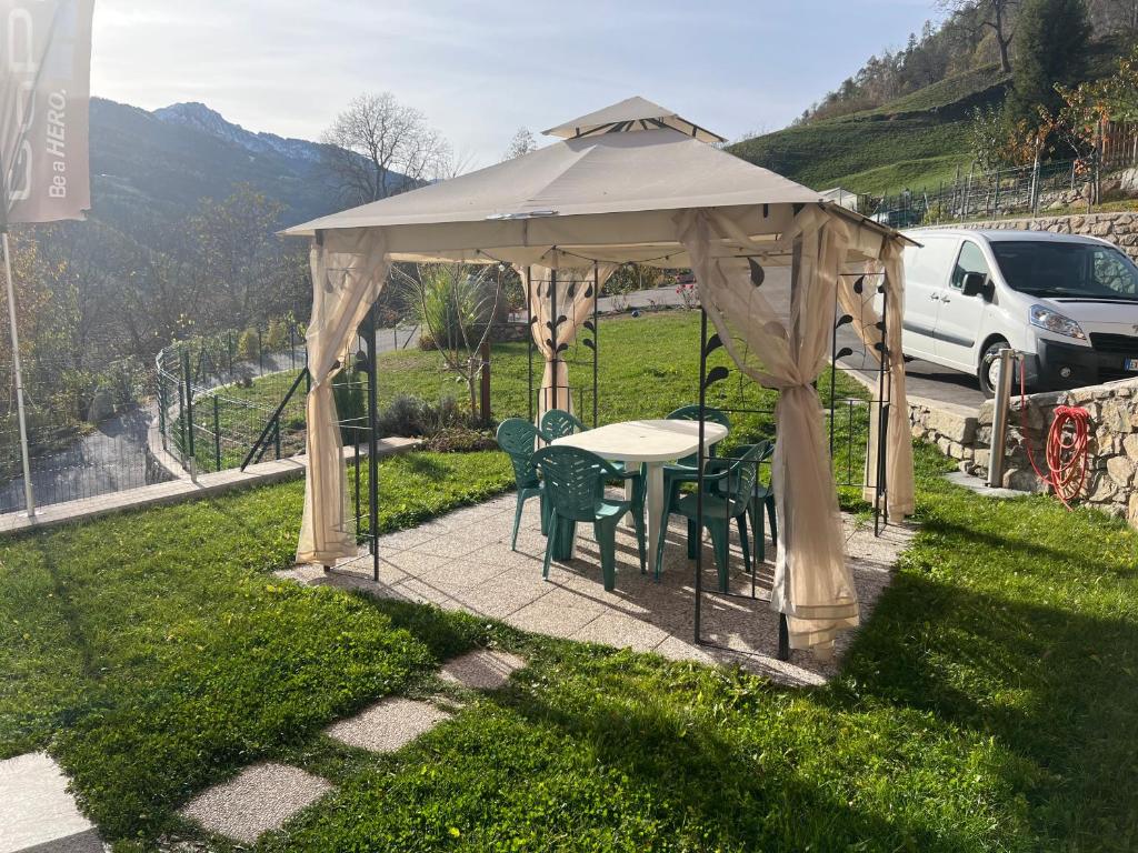 a gazebo with a table and chairs under it at Appartamento Sara in Commezzadura