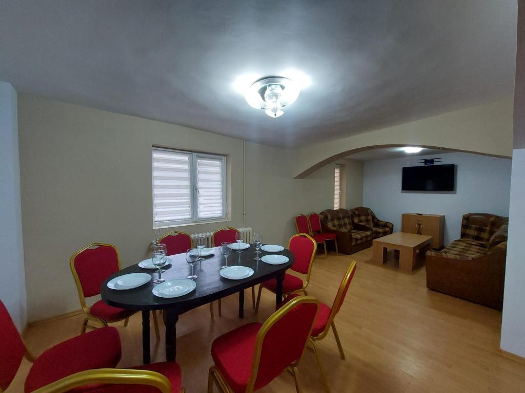 comedor con mesa y sillas rojas en Casa NIB Calimanesti en Călimăneşti