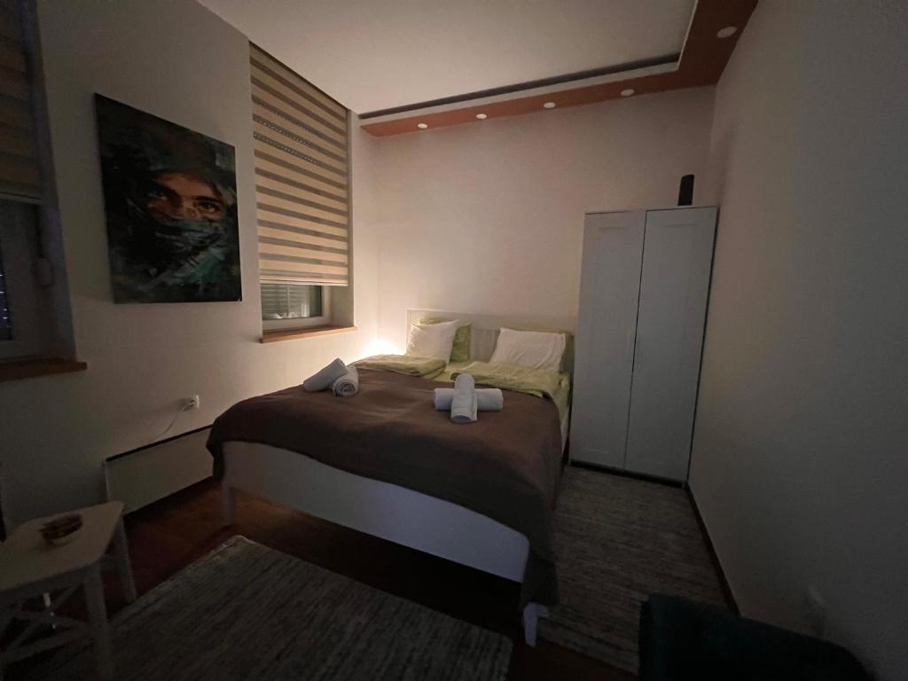 een kleine slaapkamer met een bed met een kruis erop bij Apartment Nora in Vračar (historical)