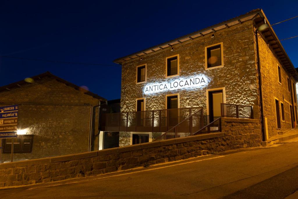 a building with a sign on the side of it at night at Antica Locanda Bonfiglio in Busana