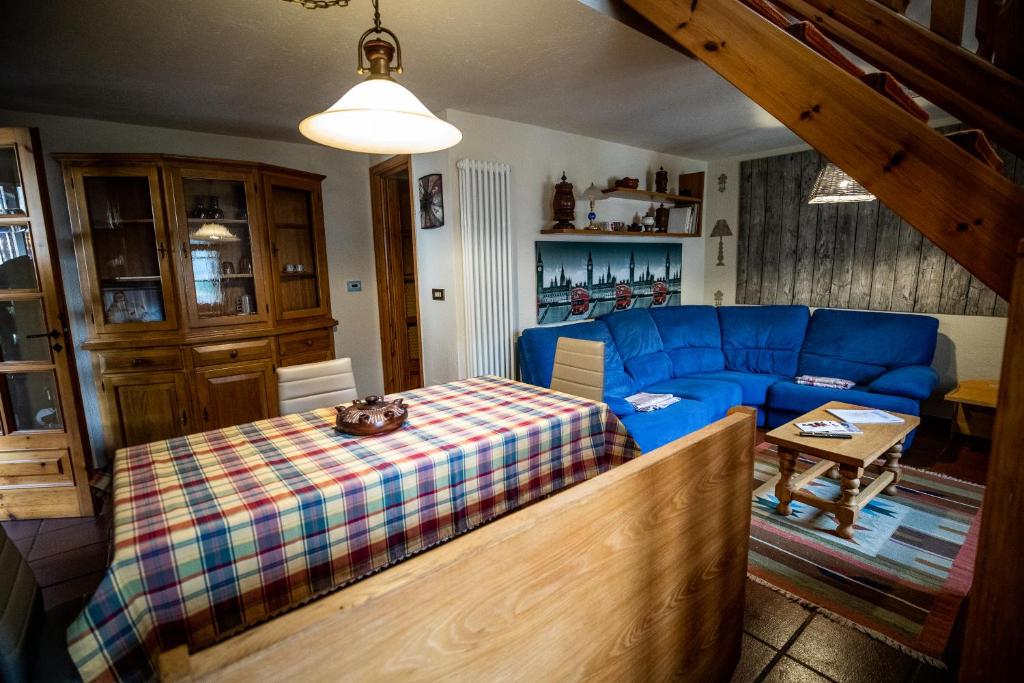 Maison La Bagne في أَويستا: غرفة معيشة مع أريكة زرقاء وطاولة