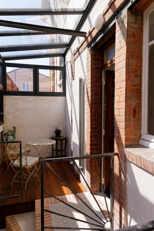 d'un balcon avec une table et une fenêtre. dans l'établissement Les Tournelles, à Courbevoie