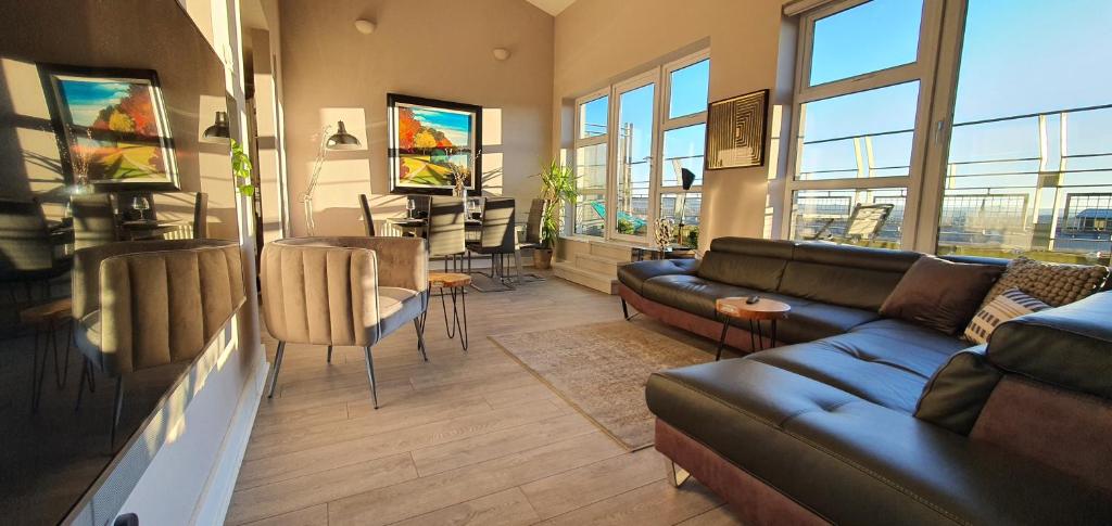 a living room with a couch and a table and chairs at The Beautiful Bankmore Penthouse in Belfast