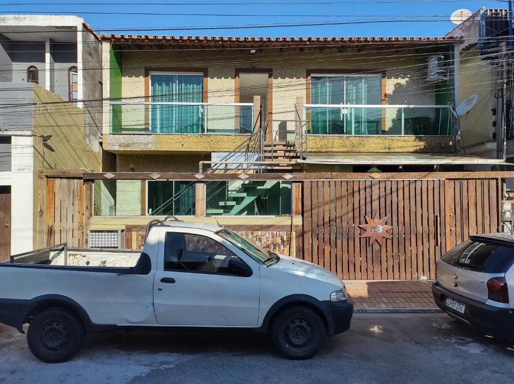 un camión blanco estacionado frente a una casa en Suítes Marechal, en Arraial do Cabo