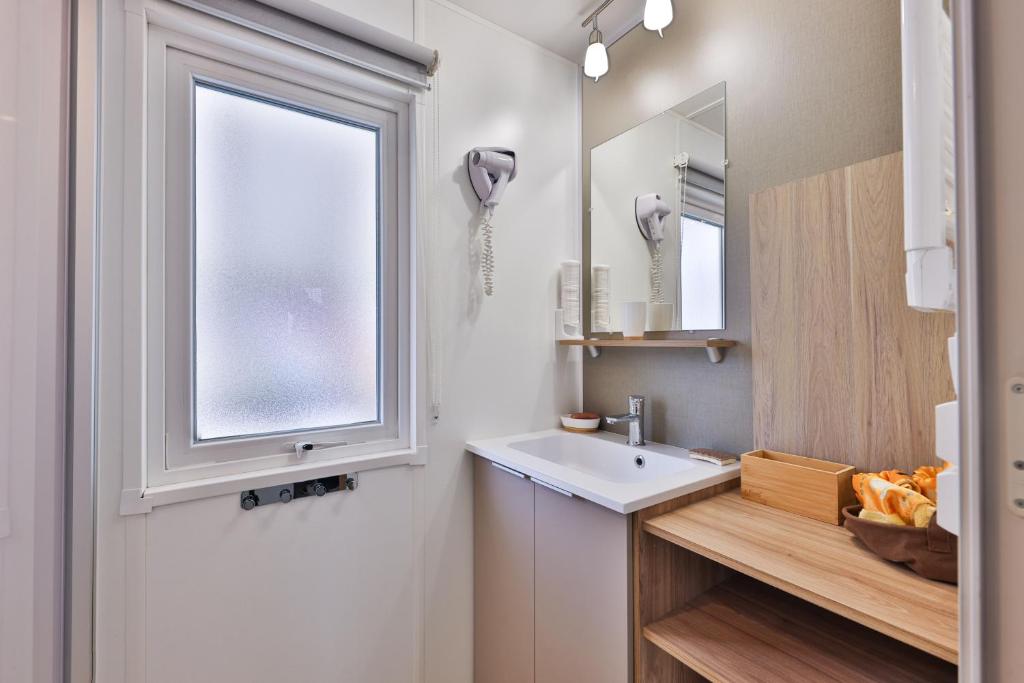 biała łazienka z umywalką i oknem w obiekcie Grand Mobil Home 6 personnes climatisé avec 3 chambres et 2 salles de bains à Munster en Alsace w mieście Munster