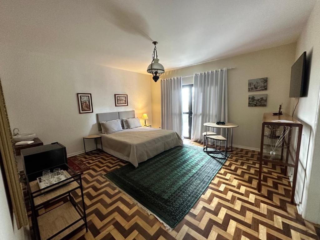 a bedroom with a bed and a television in a room at Deck Hospedaria in Cunha