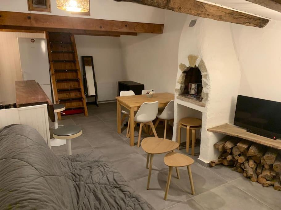 salon ze stołem i kominkiem w obiekcie Superbe duplex vue montagne. w mieście Gréolières