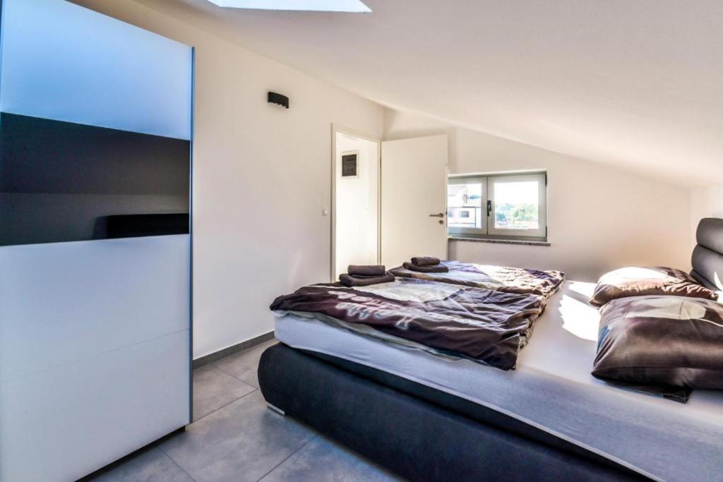 sypialnia z łóżkiem i dużym lustrem w obiekcie Apartments Lia-Jolie w mieście Umag