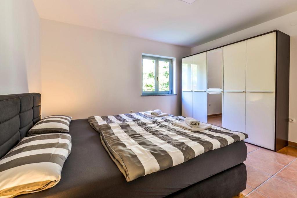 sypialnia z dużym łóżkiem i szafką w obiekcie Apartments Lia-Jolie w mieście Umag