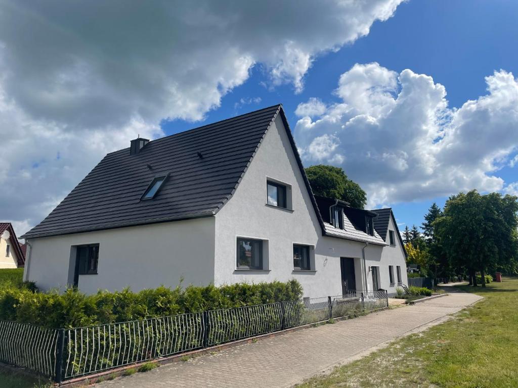 a white house with a black roof at Ferienhaus L45 in Elsterheide