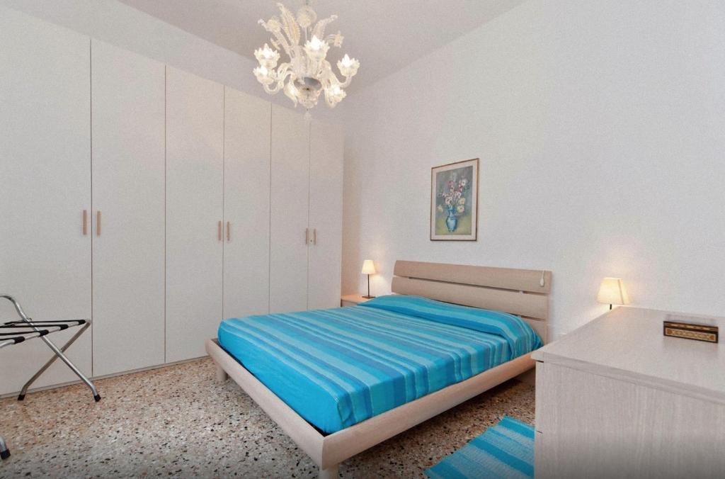 Habitación blanca con cama y lámpara de araña. en Ca' Gioiosa Venice, en Venecia