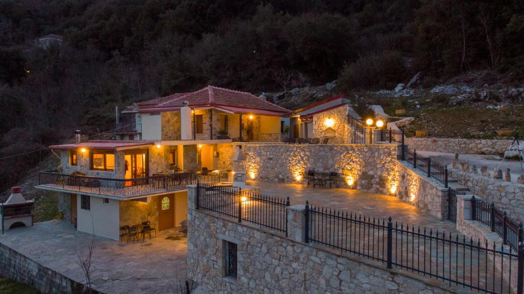 a large house with lights on it at night at Casa Margarita cozy & peaceful stay in Tzoumerka in Ioannina
