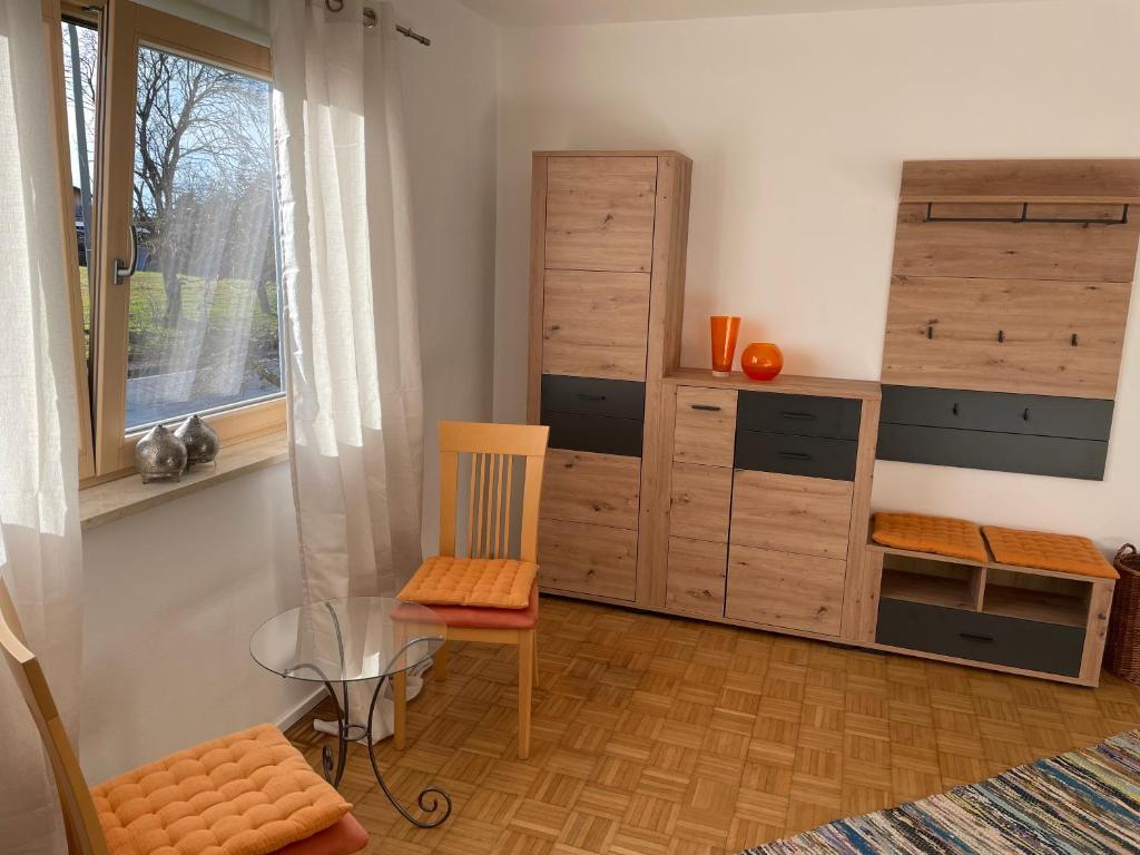 een woonkamer met een glazen tafel en een stoel bij Haus Wiesenblick in Thurmansbang