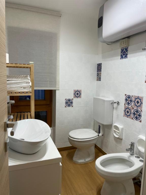 a bathroom with a white toilet and a sink at Desiree Apartment in Folgarida