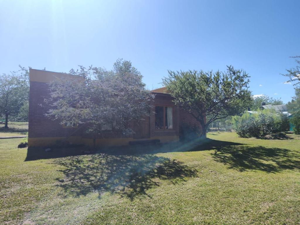 a house in the middle of a grass field at El Espinillo, Casa de Campo in Santa Rosa de Calamuchita