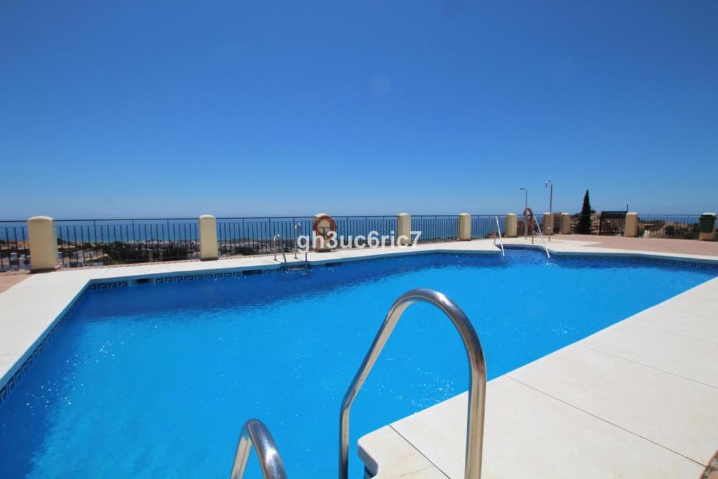 una gran piscina azul con barandillas metálicas en Beautiful appartment Mijas Costa, en Mijas