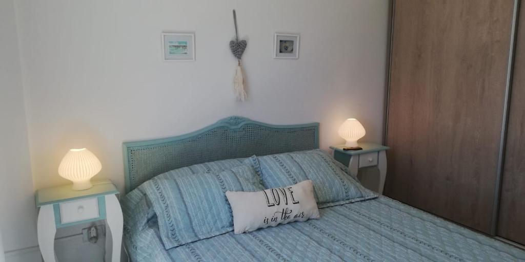 een slaapkamer met een blauw bed en 2 nachtkastjes bij Pardelas patagonia in Puerto Madryn
