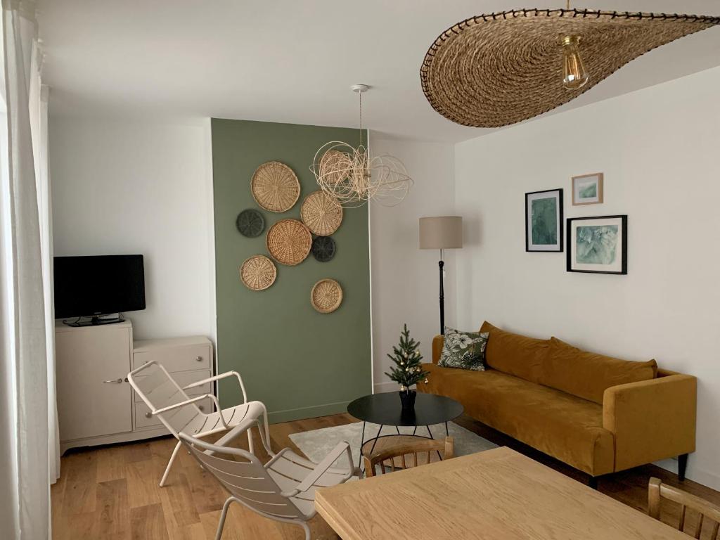 a living room with a couch and a table and chairs at Champagne! Appartement spacieux Reims centre in Reims