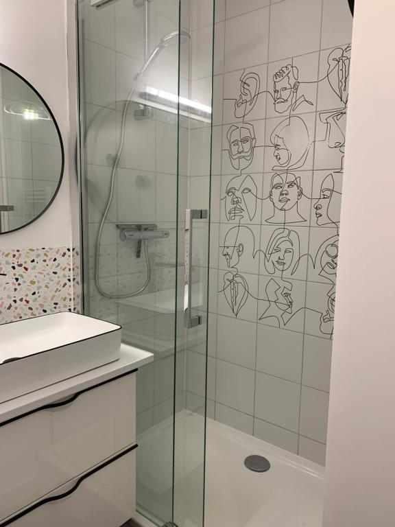 a bathroom with a shower with a glass door at Champagne! Appartement spacieux Reims centre in Reims