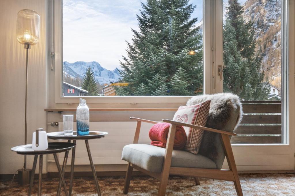 a living room with a chair and a large window at Flat close to Zermatt - Klein Matterhorn view in Randa