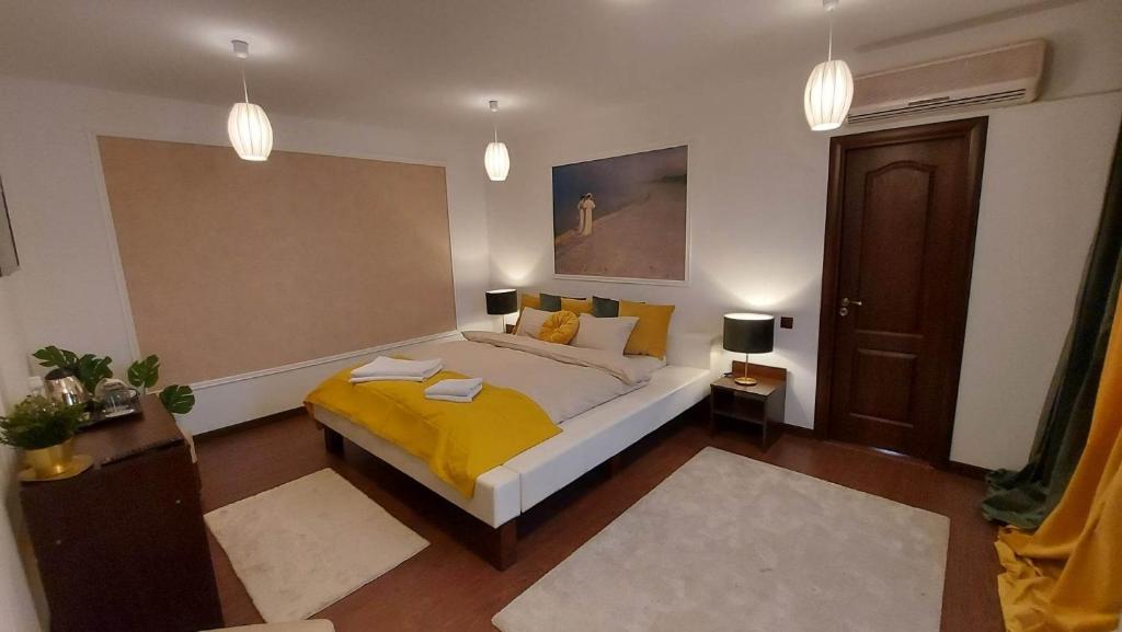 a bedroom with a bed with a yellow blanket at Ambiennt in Bucharest