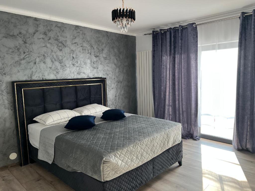 a bedroom with a large bed with blue pillows at Sarah relax2 in Drobeta-Turnu Severin