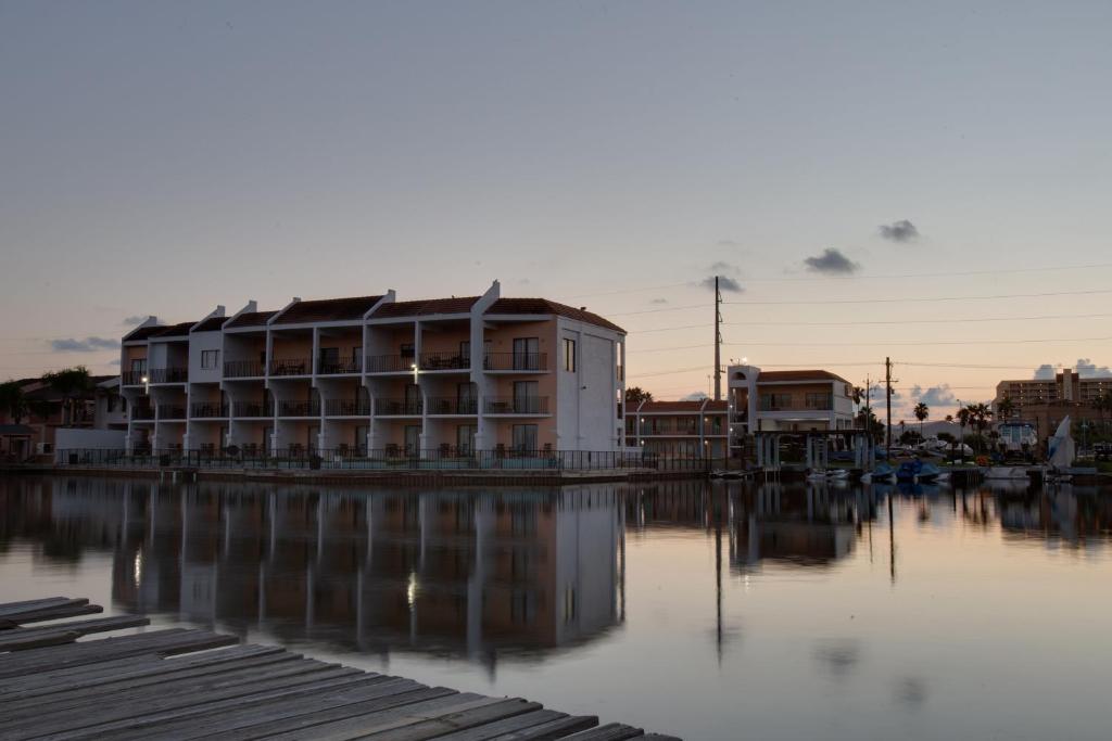 a building sitting next to a body of water at WindWater Hotel and Marina in South Padre Island