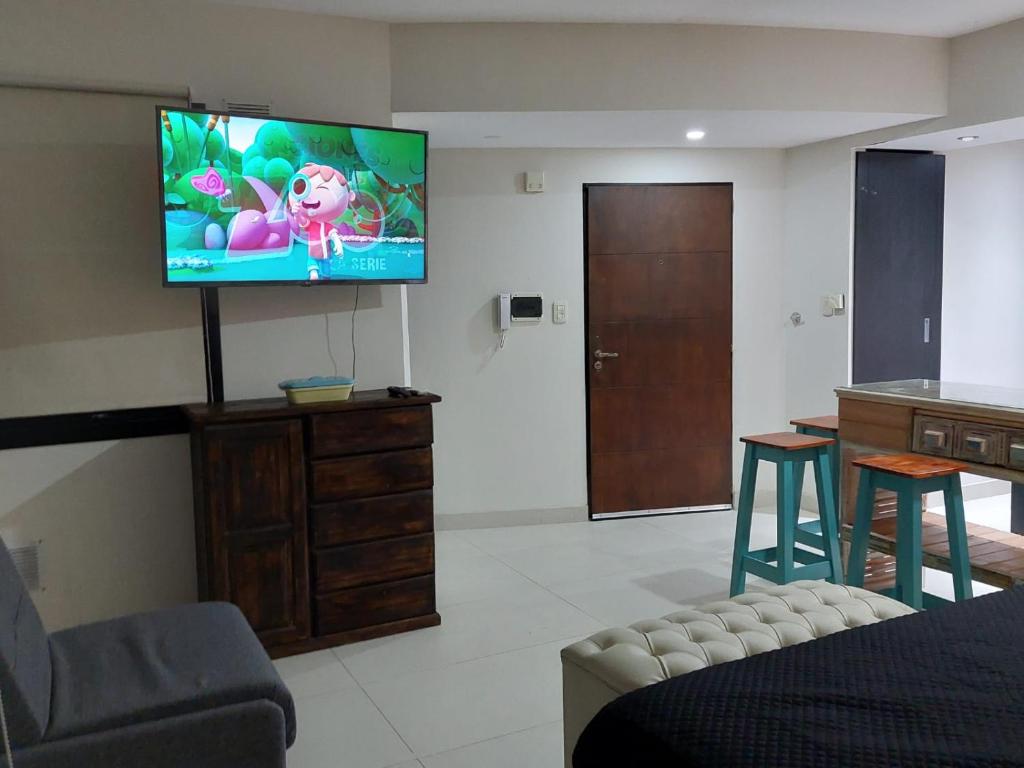 a living room with a flat screen tv on a wall at OBLIGADO ESTUDIO SAN PEDRO in San Pedro