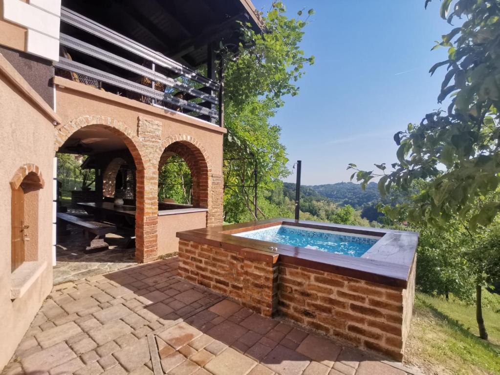 una piscina all'aperto con arco e un edificio in mattoni di Kuća za odmor Mila a Tuheljske Toplice