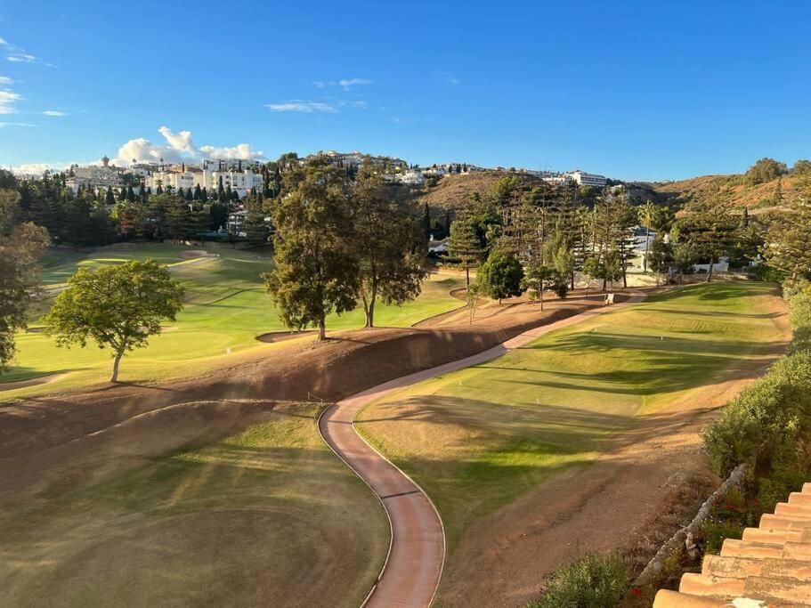 - Vistas a un campo de golf con árboles y a una carretera en Appartement Limonar del Golf - Full Option, en Mijas Costa