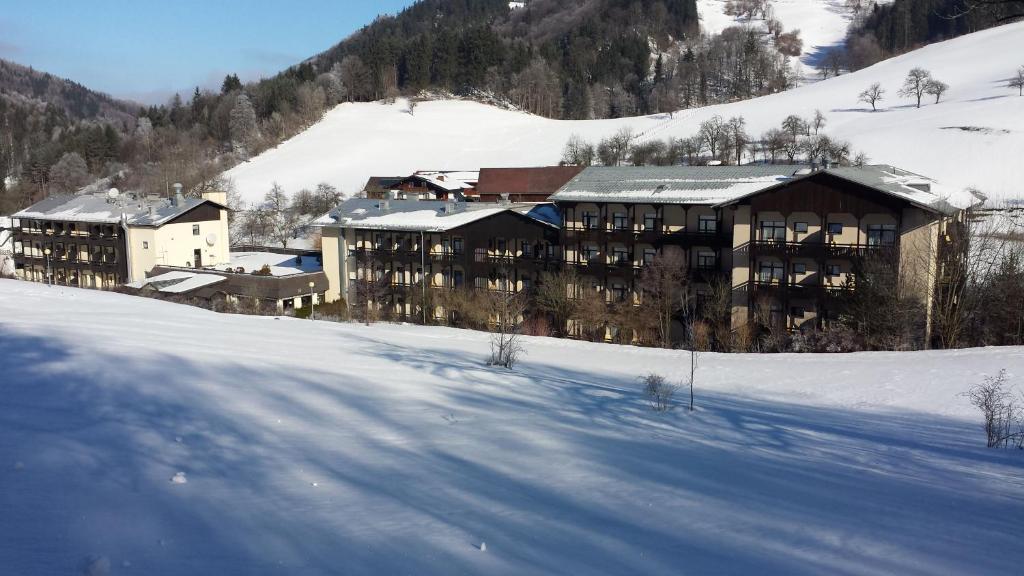a large building in the snow in front of a mountain at Gesundheits- & Wellnessresort Salzerbad in Kleinzell