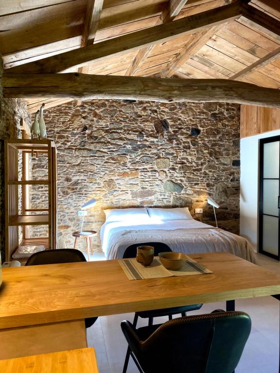 Schlafzimmer mit einem Bett und einem Holztisch in der Unterkunft Lar do Gado in Porta