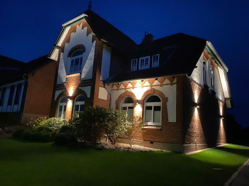 une maison avec des lumières à l'avant de celle-ci la nuit dans l'établissement Das Föhs, à Eckernförde