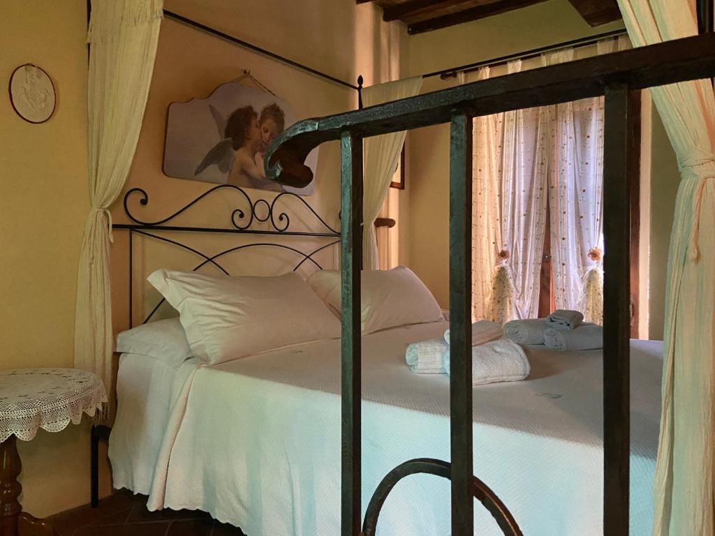 um quarto com uma cama de dossel e almofadas brancas em Agriturismo Relais Villa Passerini em Grosseto