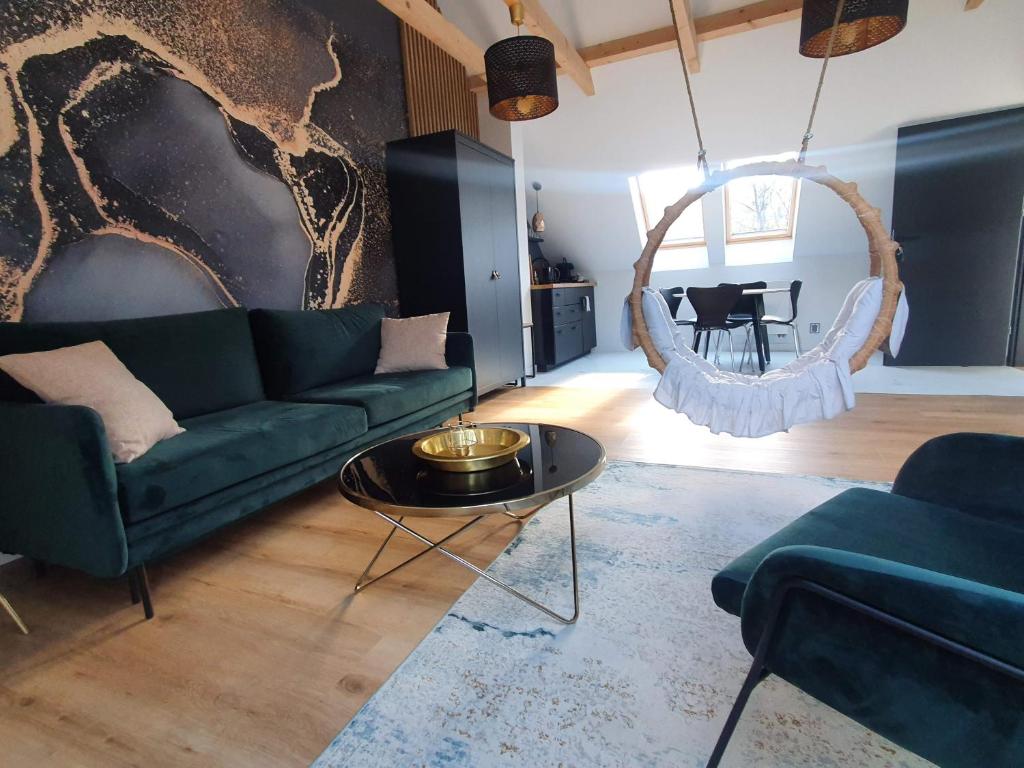 ein Wohnzimmer mit einem grünen Sofa und einem Tisch in der Unterkunft Ogrodowa 4 in Ustrzyki Dolne