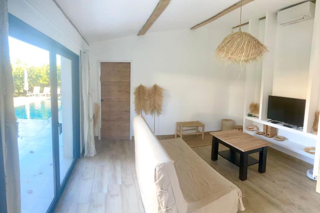 a living room with a bed and a tv and a table at Maison Piscine Sauna 5min Centre Aix - Casa G. in Aix-en-Provence