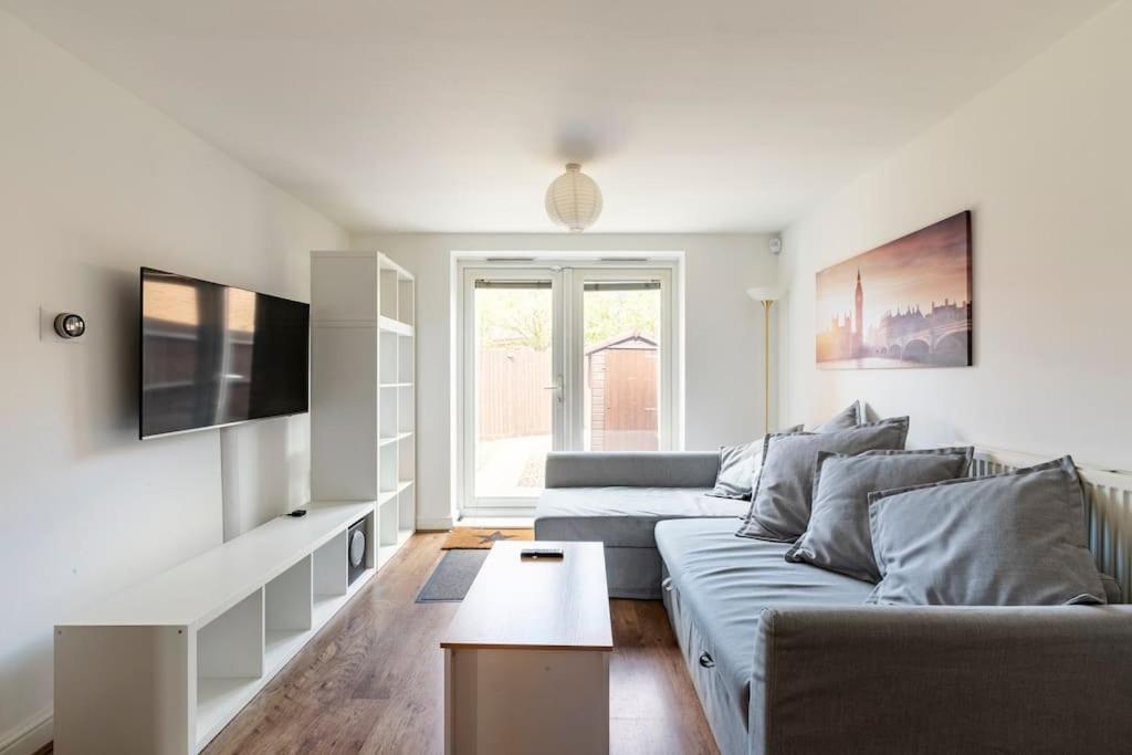 uma sala de estar com um sofá e uma televisão em Modern & Stylish 2 Bedroom Apartment! - Ground Floor - FREE Parking for 2 Cars - Netflix - Disney Plus - Sky Sports - Gigabit Internet - Newly decorated - Sleeps up to 5! - Close to Bournemouth Train Station em Bournemouth