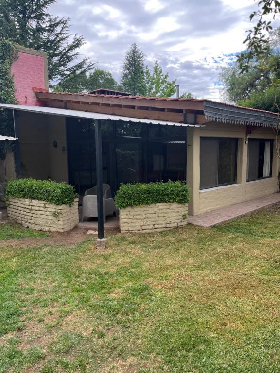 a house with glass doors and a grass yard at La Oma. Casa en Chacras de Coria in Ciudad Lujan de Cuyo