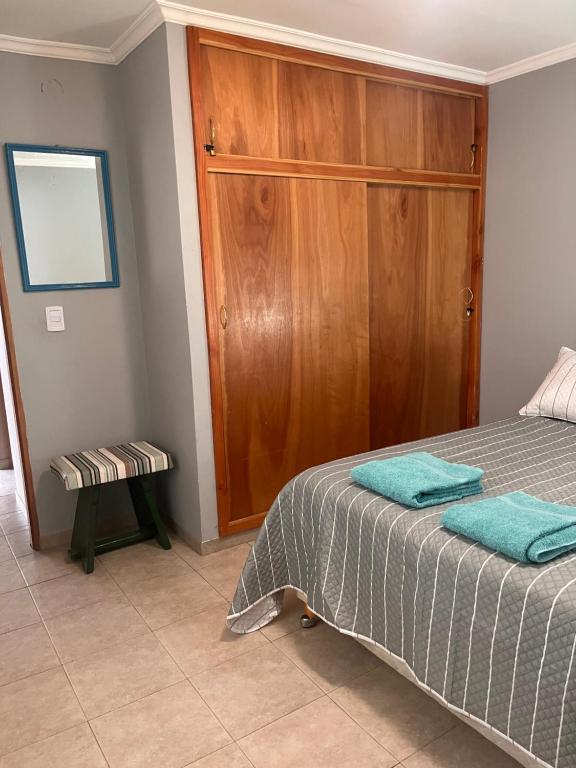 1 dormitorio con 1 cama y armario de madera en Casa Nogal en El Bolsón