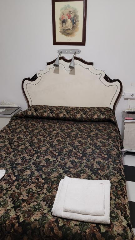 a bed with a white pillow sitting on top of it at Pensión San Benito Abad in Seville