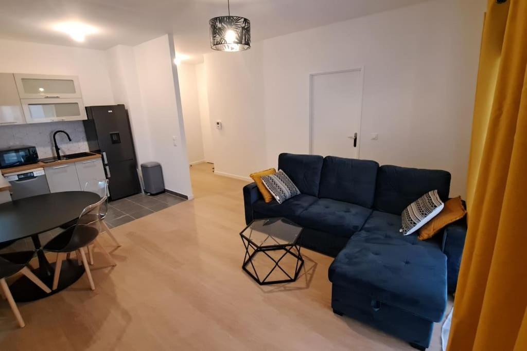 a living room with a blue couch and a table at Chez David in Villejuif