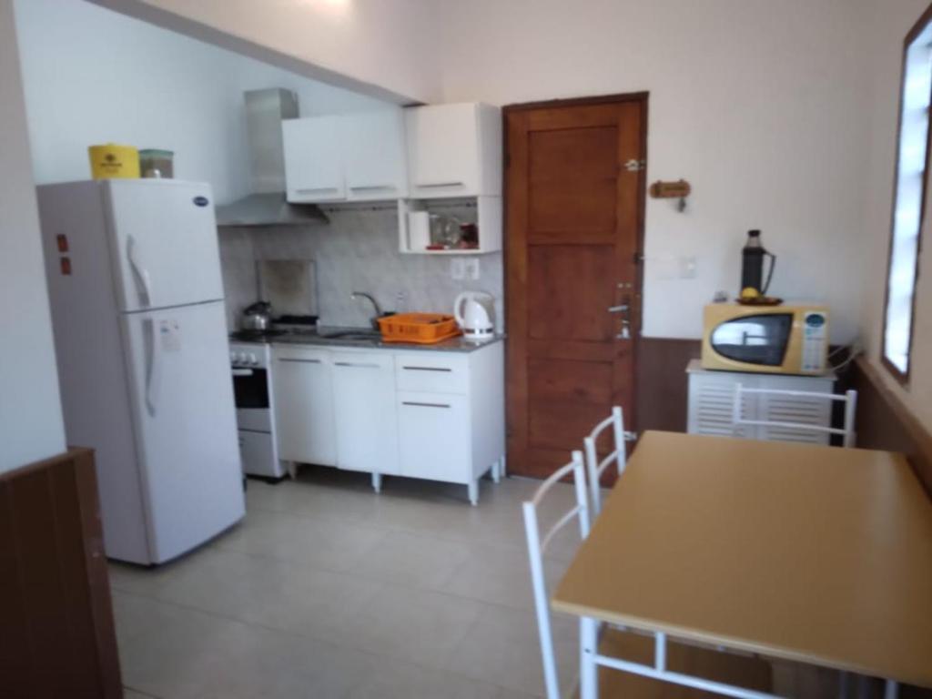 cocina con nevera blanca y mesa con sillas en Casa en La Aguada, en La Paloma