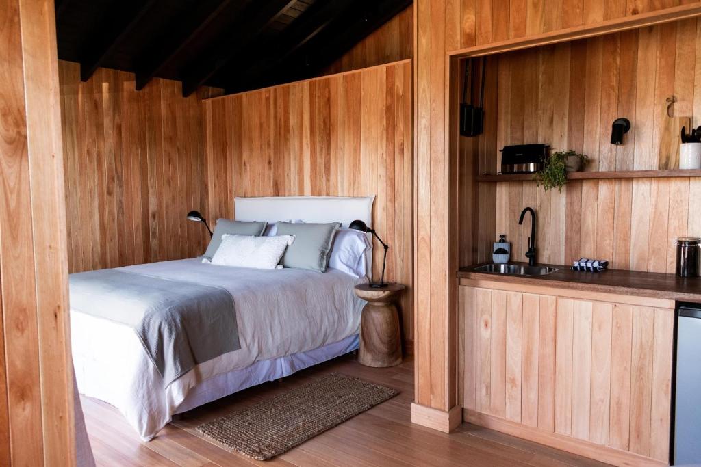 um quarto com uma cama numa parede de madeira em Aires Puros em José Ignacio