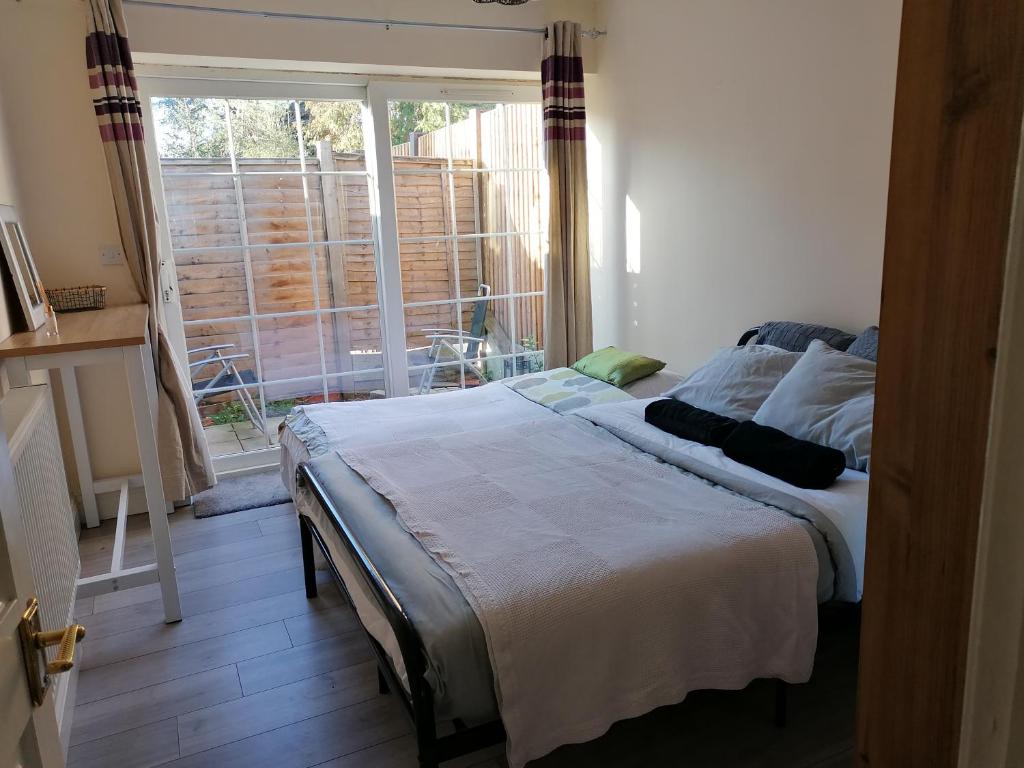 a bedroom with a bed and a large window at Chantilly in Ickenham