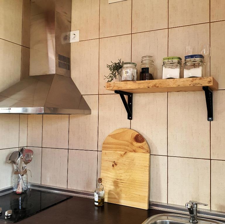 a kitchen with a sink and a shelf with jars at Apartamento Rural El Ciprés Complejo la Fontanina in Mata de Alcántara