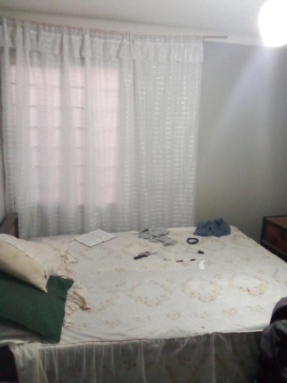 a messy bed in a bedroom with a window at No. 271 in Mexico City