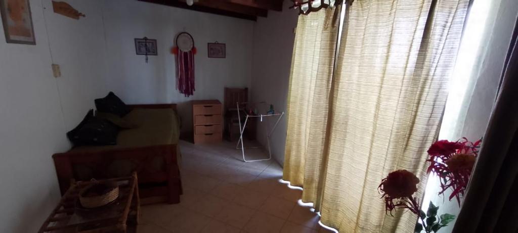 a room with curtains and a bedroom with a dresser at Depto centro in Villa Gesell